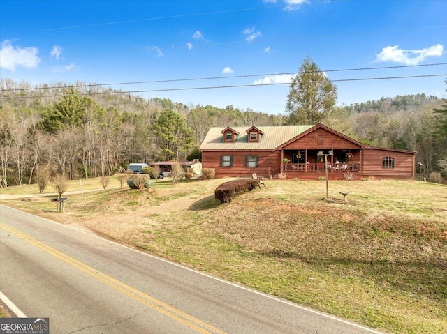 rustic home featuring a porch, metal roof, and a front lawn