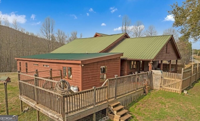 back of property featuring metal roof and a wooden deck