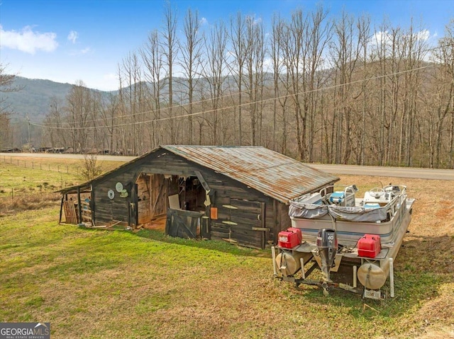 view of outbuilding featuring an outdoor structure, a forest view, and a mountain view