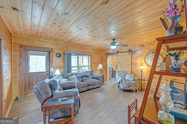 living room with wood ceiling, wood walls, a barn door, and wood finished floors