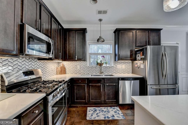 kitchen with visible vents, dark brown cabinets, appliances with stainless steel finishes, decorative backsplash, and crown molding