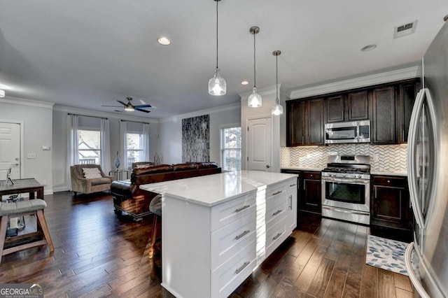 kitchen with visible vents, decorative backsplash, dark wood-style floors, stainless steel appliances, and a healthy amount of sunlight