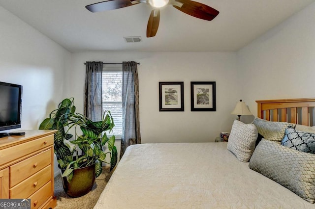 carpeted bedroom with a ceiling fan and visible vents