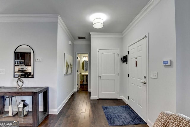 entrance foyer featuring baseboards, visible vents, dark wood-style flooring, and ornamental molding