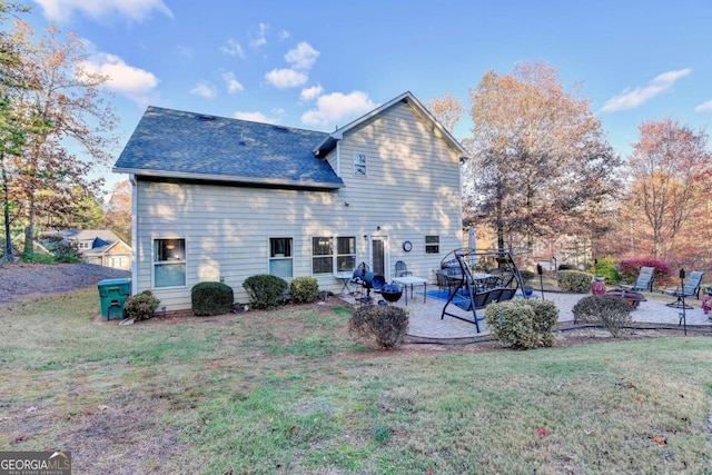 back of house with a patio area, a shingled roof, and a lawn