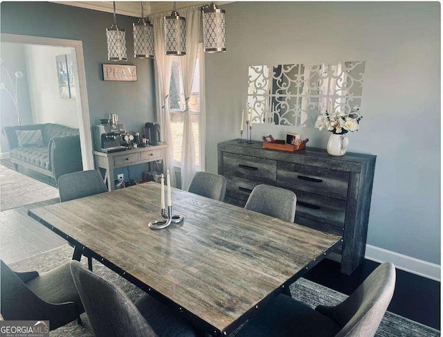 dining space with baseboards and wood finished floors