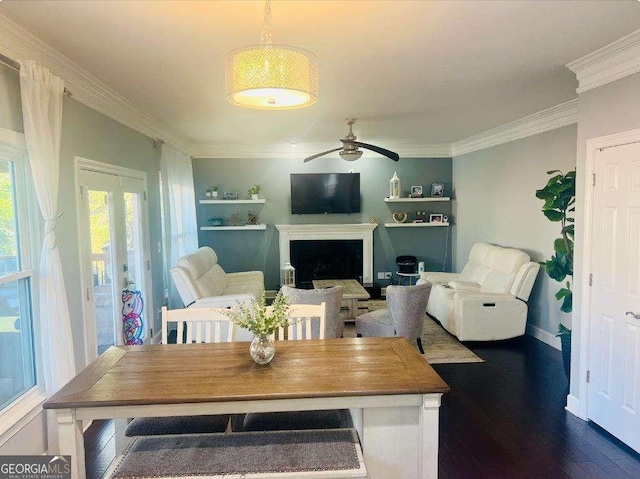 interior space with baseboards, dark wood finished floors, ceiling fan, crown molding, and a fireplace