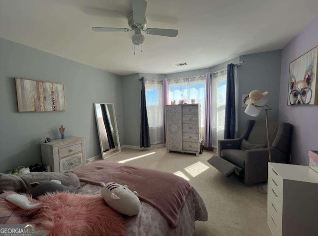 bedroom with baseboards, a ceiling fan, visible vents, and light colored carpet