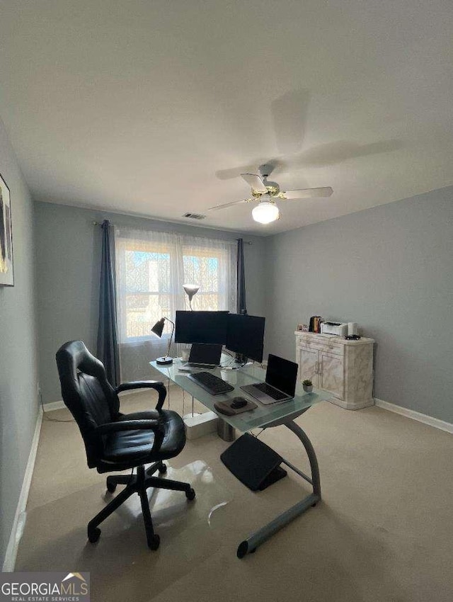 carpeted office with a ceiling fan, visible vents, and baseboards