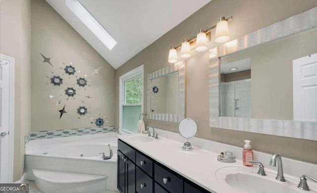 full bathroom with vaulted ceiling with skylight, a sink, a whirlpool tub, and double vanity