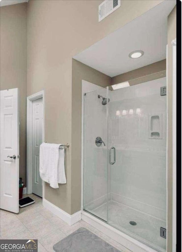 bathroom with baseboards, a shower stall, visible vents, and tile patterned floors