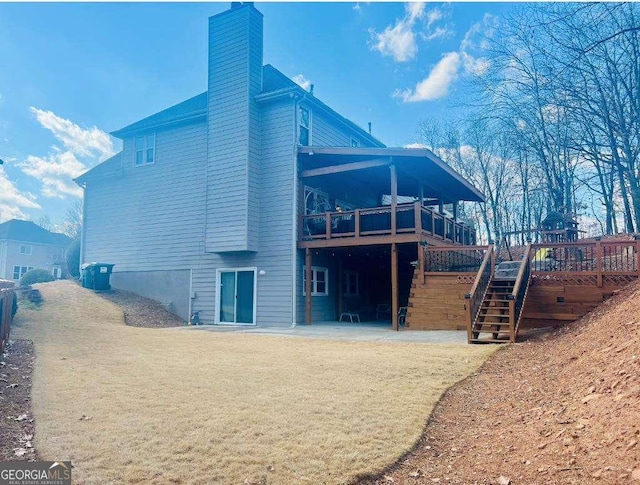 view of property exterior featuring a chimney, a wooden deck, and stairs