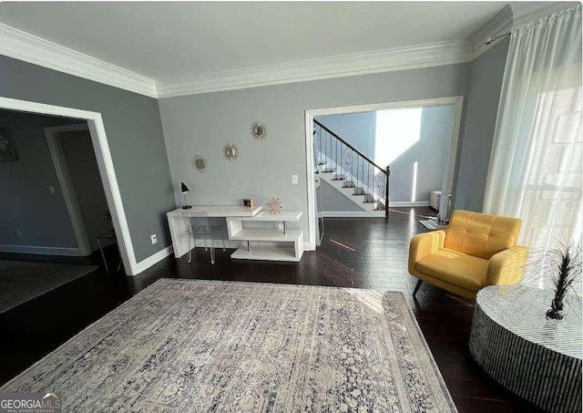 living room featuring stairs, baseboards, wood finished floors, and ornamental molding