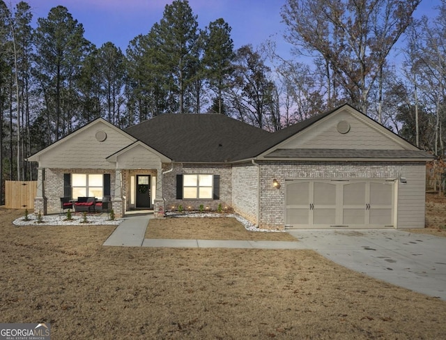 view of front of home with brick siding, driveway, an attached garage, and roof with shingles