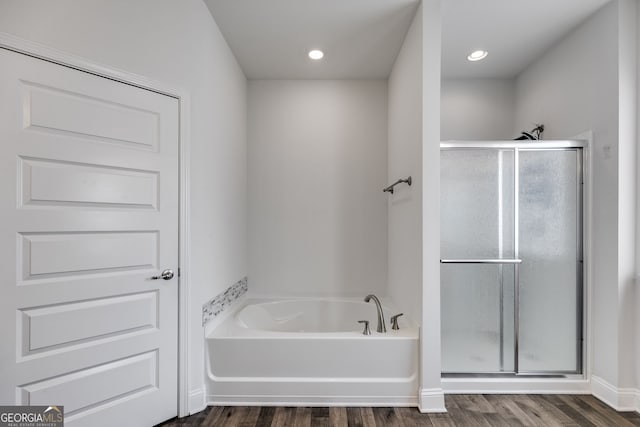 bathroom featuring wood finished floors, a shower stall, a bath, and recessed lighting