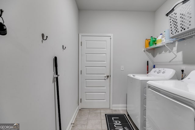 laundry room featuring laundry area, light tile patterned floors, baseboards, and separate washer and dryer