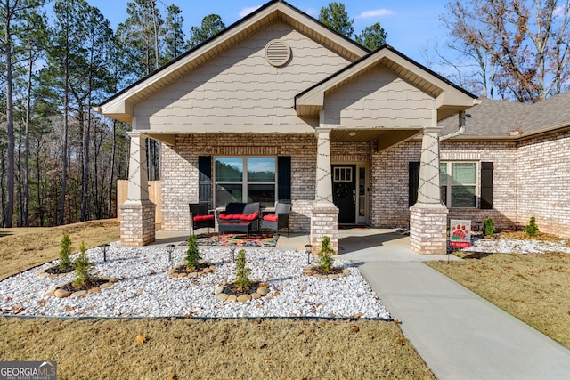 craftsman inspired home featuring brick siding and a porch