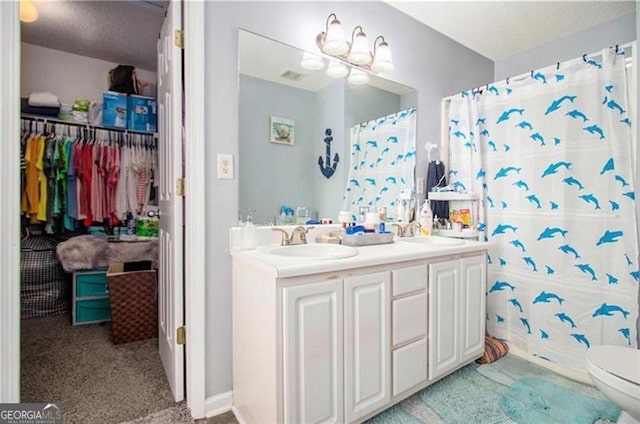 full bath featuring double vanity, curtained shower, a sink, and toilet