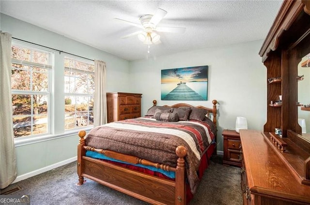 carpeted bedroom with a ceiling fan, multiple windows, baseboards, and a textured ceiling