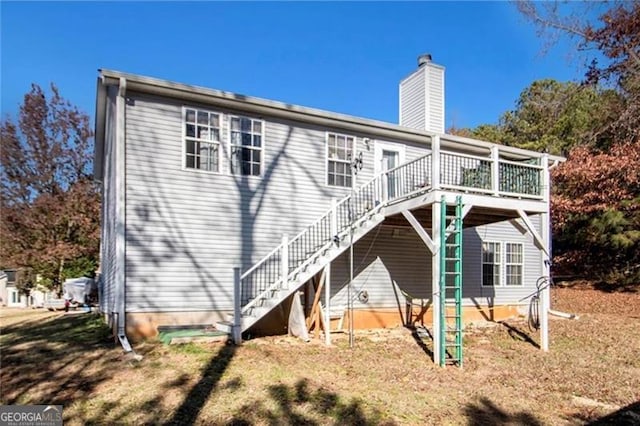 rear view of house featuring a deck, a chimney, and stairway