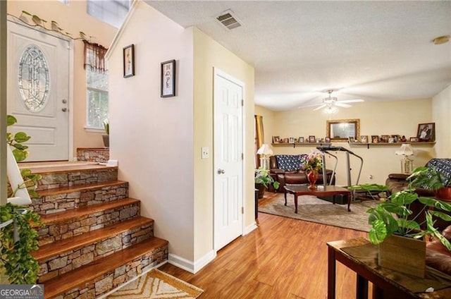 interior space featuring visible vents, ceiling fan, baseboards, and wood finished floors