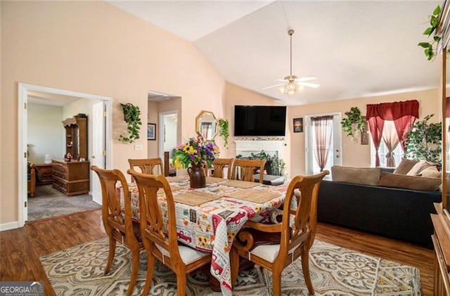 dining room featuring ceiling fan, high vaulted ceiling, and wood finished floors