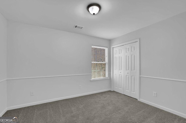 unfurnished bedroom with carpet floors, a closet, visible vents, and baseboards