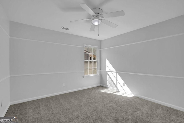 carpeted empty room with a ceiling fan, visible vents, and baseboards