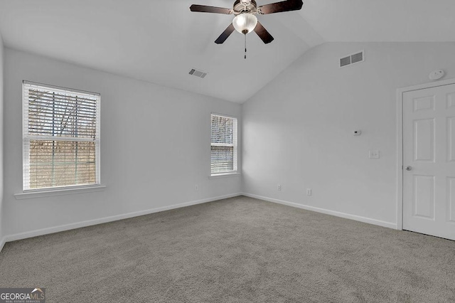 unfurnished room with carpet floors, visible vents, vaulted ceiling, and baseboards