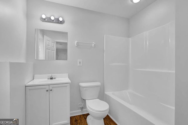 bathroom featuring baseboards, toilet, wood finished floors, vanity, and washtub / shower combination