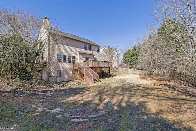 back of property featuring stairs, a deck, a chimney, and fence