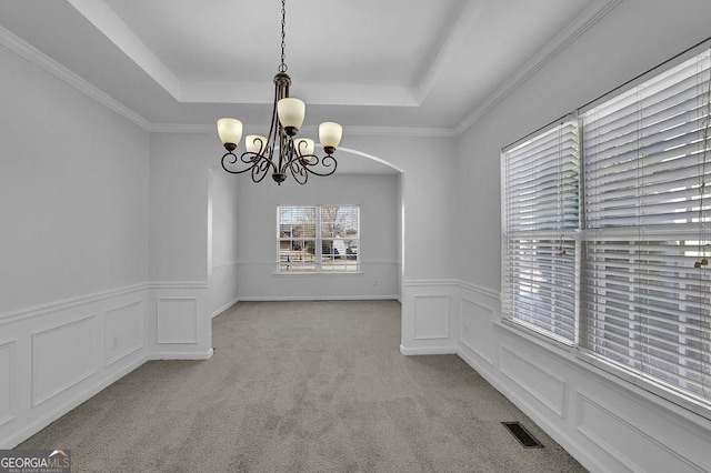 unfurnished dining area featuring carpet, a raised ceiling, visible vents, and a decorative wall