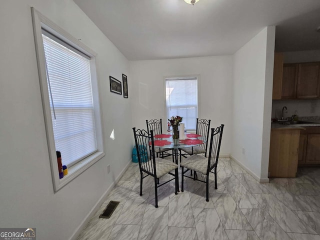 dining area featuring marble finish floor, visible vents, and baseboards