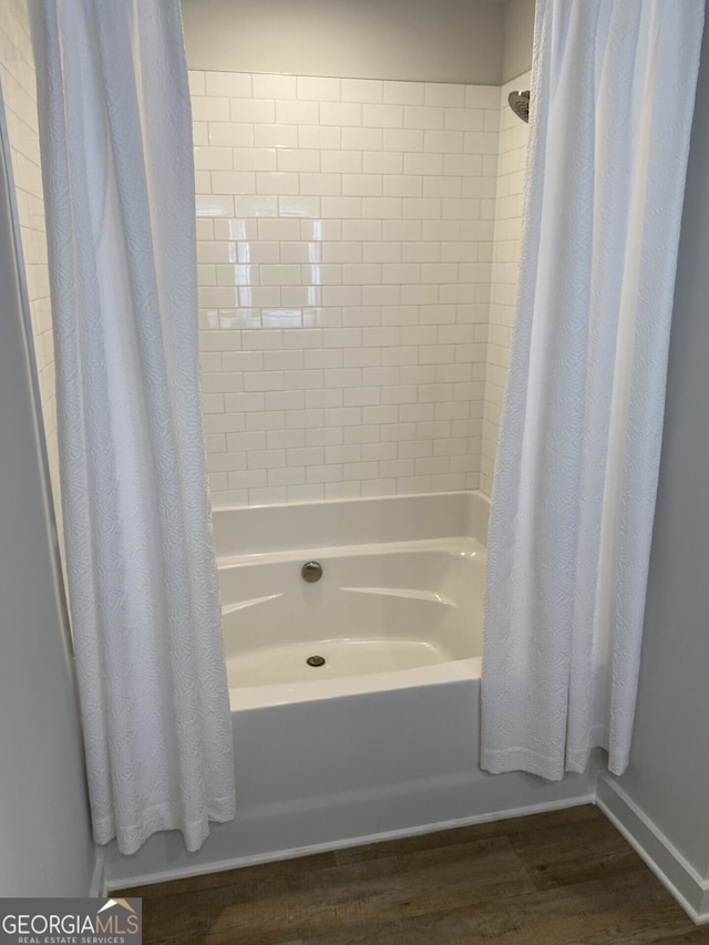 bathroom featuring shower / bath combo with shower curtain and wood finished floors