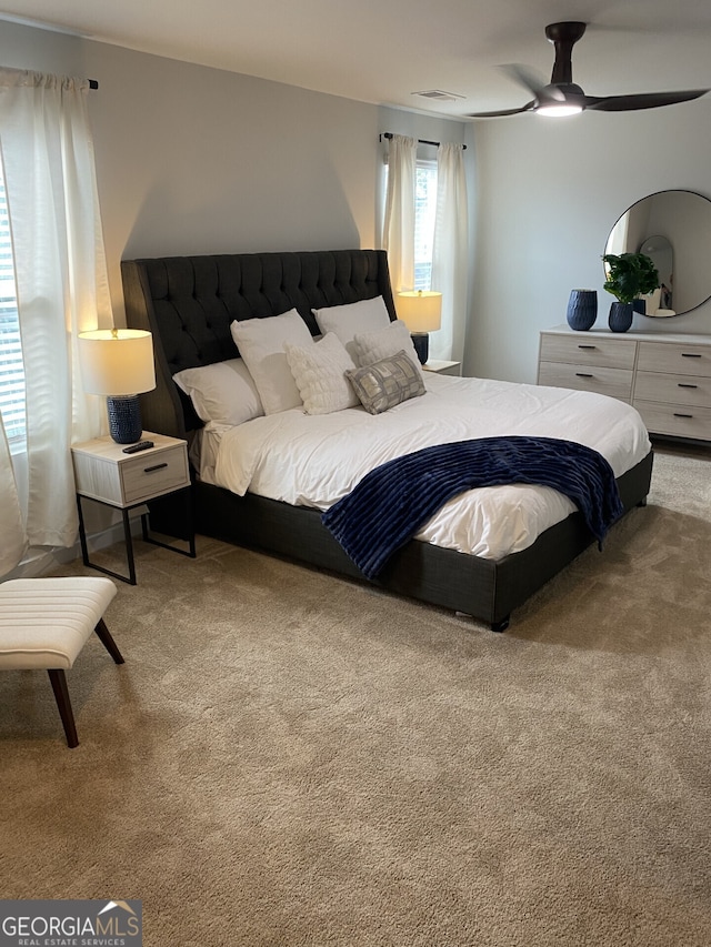 bedroom featuring carpet floors, visible vents, and ceiling fan