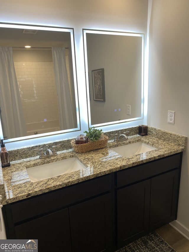 full bath featuring shower / tub combo with curtain, a sink, and double vanity