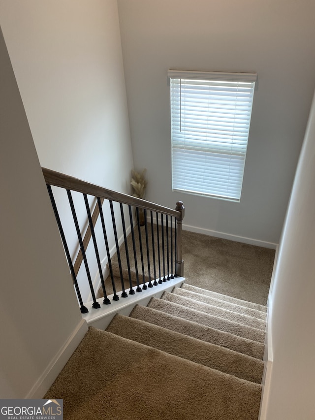 stairway with carpet floors and baseboards