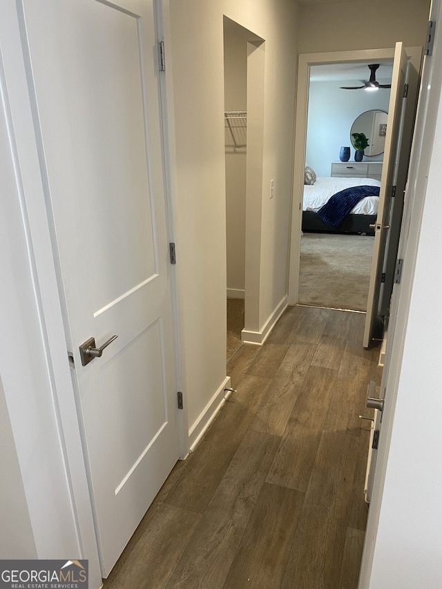 hall featuring dark wood-style floors and baseboards