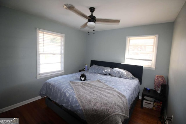 bedroom featuring multiple windows, baseboards, and wood finished floors