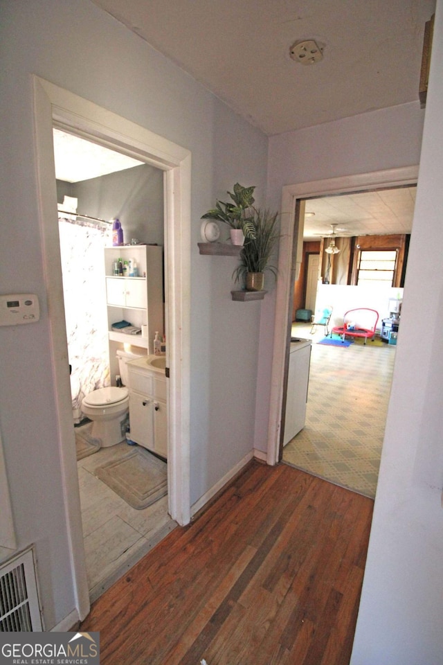 hallway with visible vents and wood finished floors