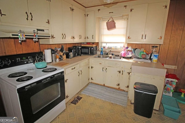 kitchen with light countertops, a sink, range with electric cooktop, black microwave, and exhaust hood