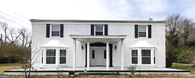 view of front of house featuring a porch and brick siding