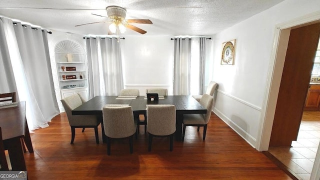 dining space featuring a ceiling fan, a textured ceiling, and wood finished floors