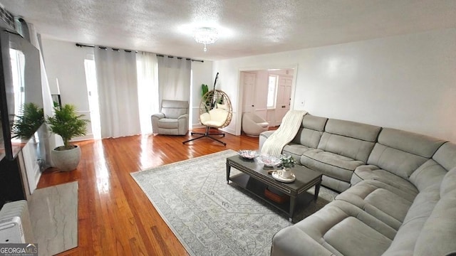 living room featuring radiator, a textured ceiling, and wood finished floors