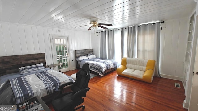 bedroom with access to exterior, visible vents, ceiling fan, and wood finished floors