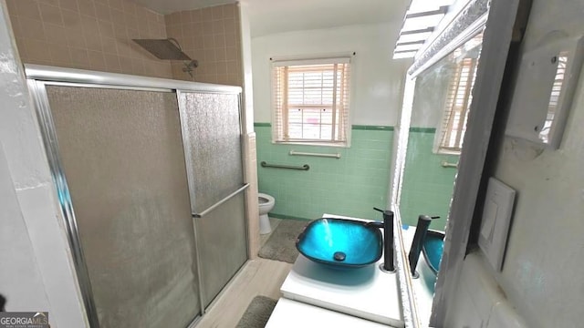 8875 E Broad St, Sparta, GA 31087 - full bathroom with tile walls, a shower stall, toilet, vanity, and wainscoting