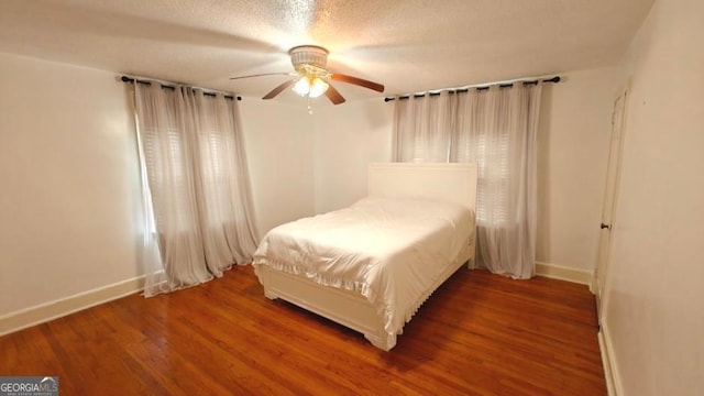 bedroom with a textured ceiling, wood finished floors, a ceiling fan, and baseboards