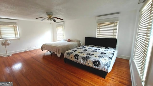 bedroom featuring ceiling fan, baseboards, and wood finished floors