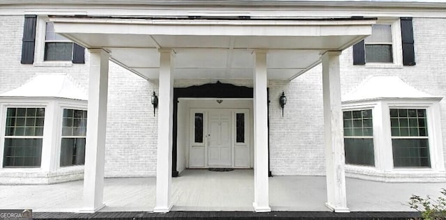 view of exterior entry featuring brick siding