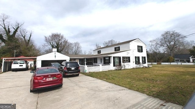 view of front of home featuring a carport, concrete driveway, and a front yard